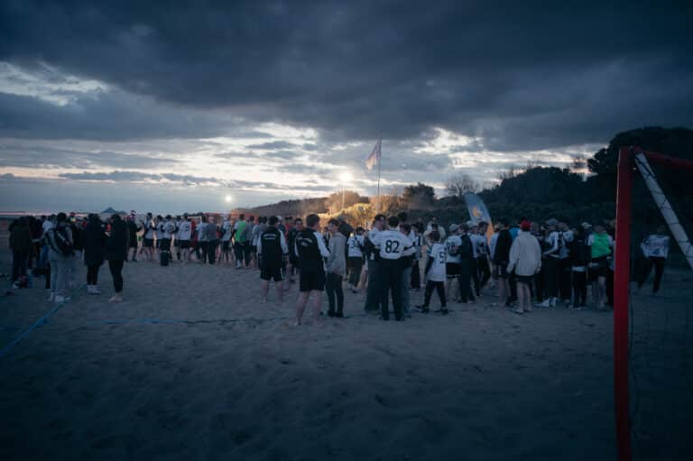 Veel handballers verzamelden zich in de schemering op een zandstrand.