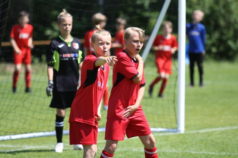 Scena del torneo di calcio giovanile: i bambini formano un muro