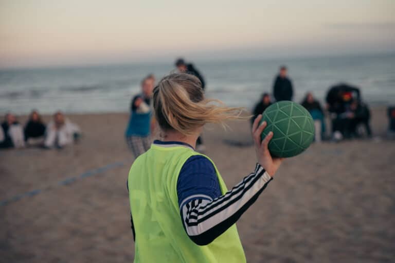 Handball Frau von wirft Handball an Strand vor dem Meer