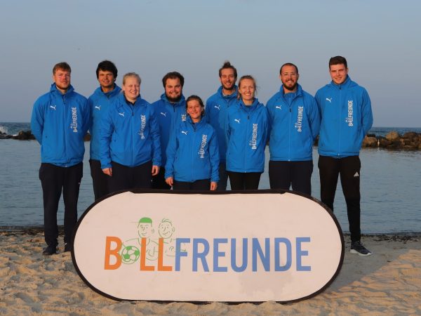 Zespół Ballfreunde na plaży z transparentem