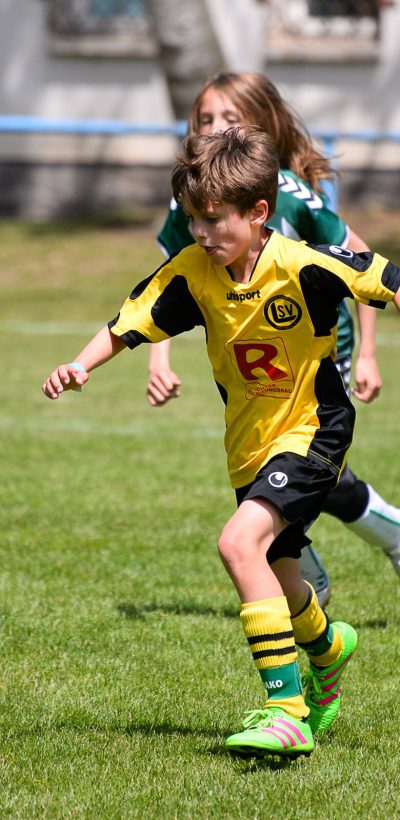 Jongen neemt het op tegen de voetbal op een Ball Friends toernooi