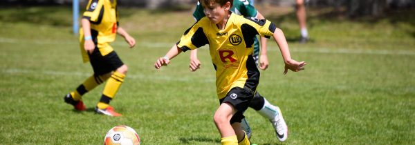 Jongen neemt het op tegen de voetbal op een Ball Friends toernooi