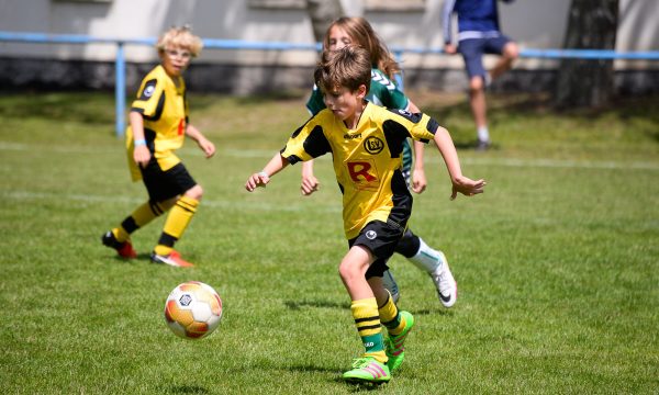 Jongen neemt het op tegen de voetbal op een Ball Friends toernooi