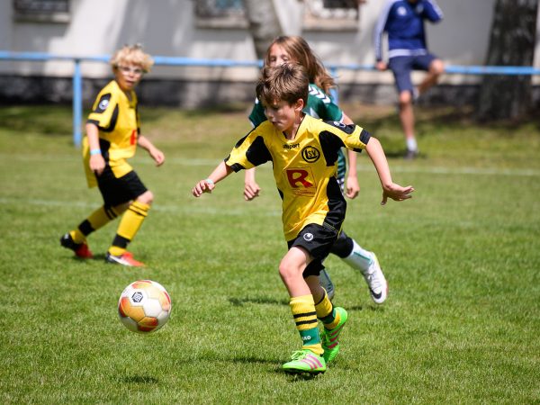 Jongen neemt het op tegen de voetbal op een Ball Friends toernooi